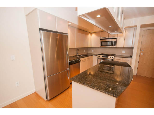 Bright kitchen with granite countertops, stainless steel appliances, and hardwood floors. - 407 - 683 Victoria Park West, North Vancouver