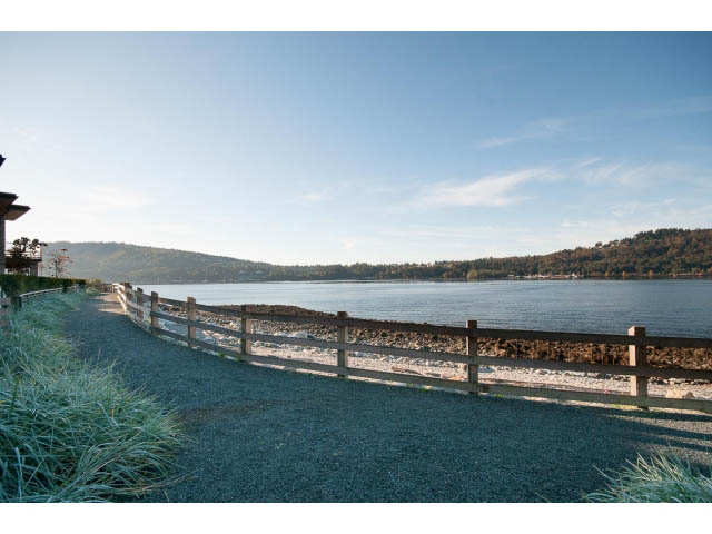 Furnished living room with a view of the water and mountains. - 203 - 3825 Cate's Landing, North Vancouver