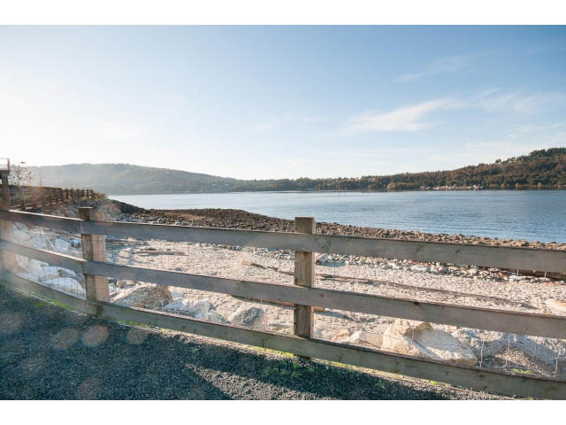 Fenced view of tranquil lake and hills, serene setting. - 203 - 3825 Cate's Landing, North Vancouver