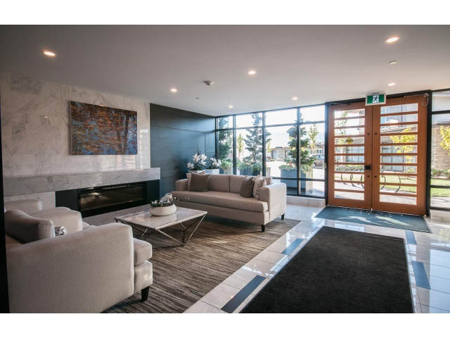 Furnished living room with marble countertops and city view. - 203 - 3825 Cate's Landing, North Vancouver