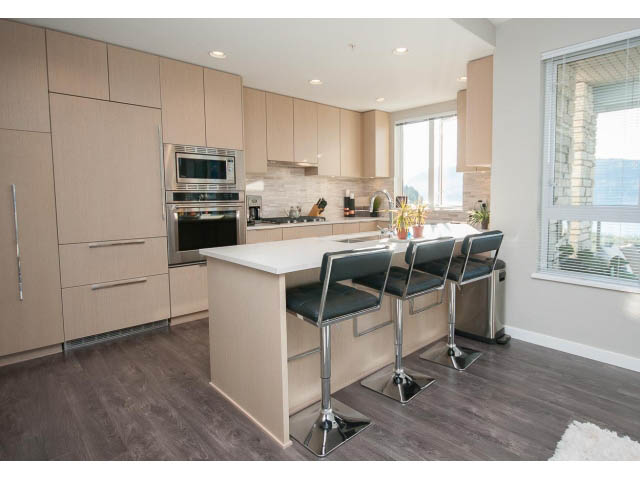 Bright kitchen with modern cabinetry, hardwood floors, and a city view. - 203 - 3825 Cate's Landing, North Vancouver