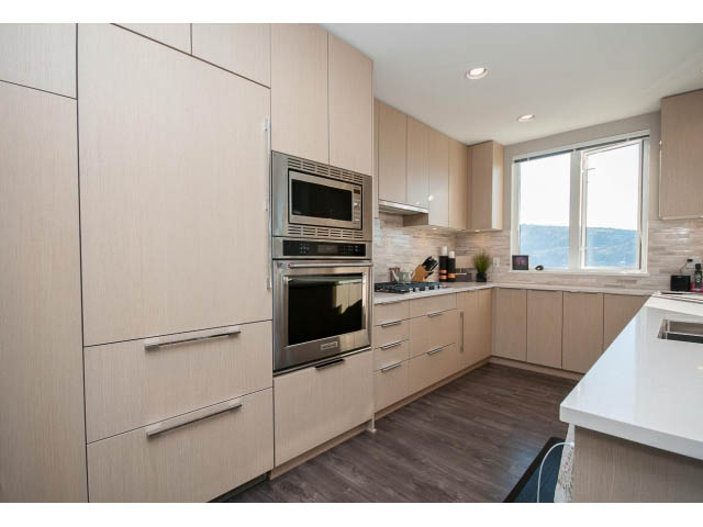Bright kitchen with light wood cabinets, stainless steel appliances, and a city view. - 203 - 3825 Cate's Landing, North Vancouver