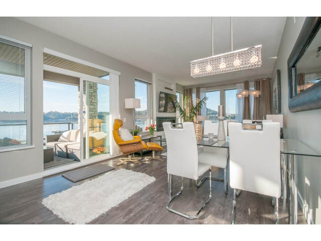 Bright living room with hardwood floors, city view, and modern furnishings. - 203 - 3825 Cate's Landing, North Vancouver