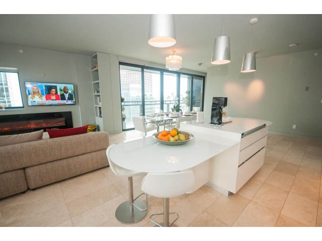 Bright kitchen with white countertops, modern bar stools, and city view. - 2301 - 838 W Hastings, Vancouver Downtown