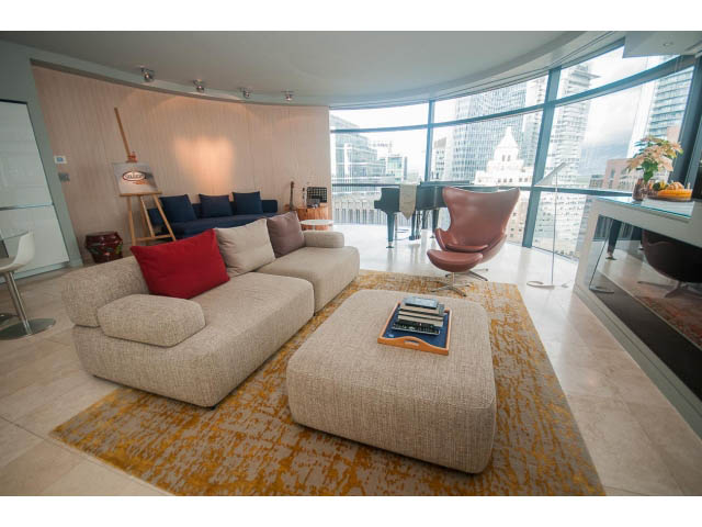 Spacious living room with modern furniture, large windows, and city view. - 2301 - 838 W Hastings, Vancouver Downtown
