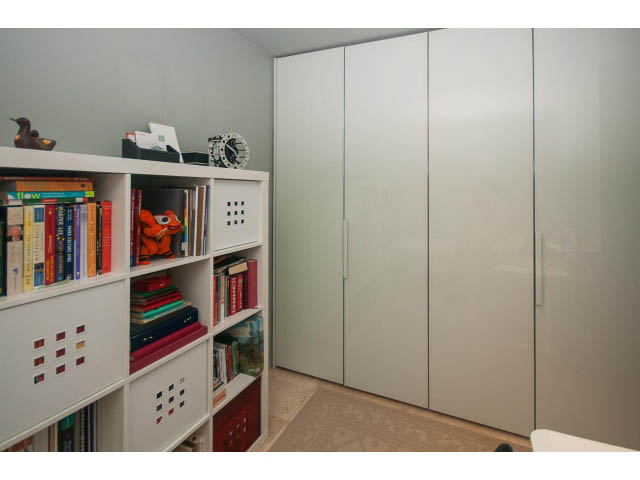Bright living room with white bookshelf and large closet, modern decor. - 2301 - 838 W Hastings, Vancouver Downtown