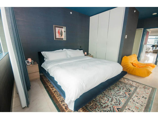 Furnished 2-bedroom + den with dark blue walls, white closet, and patterned rug. - 2301 - 838 W Hastings, Vancouver Downtown