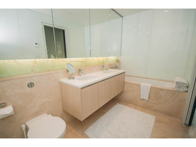 Furnished bathroom with marble countertops and large mirror. - 2301 - 838 W Hastings, Vancouver Downtown