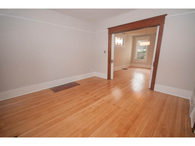 Bright living room with hardwood floors and a large window. - 516 E 10th Ave, Vancouver East Side