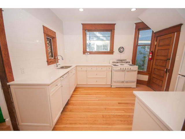 Bright kitchen with white countertops, hardwood floors, and a window view. - 516 E 10th Ave, Vancouver East Side