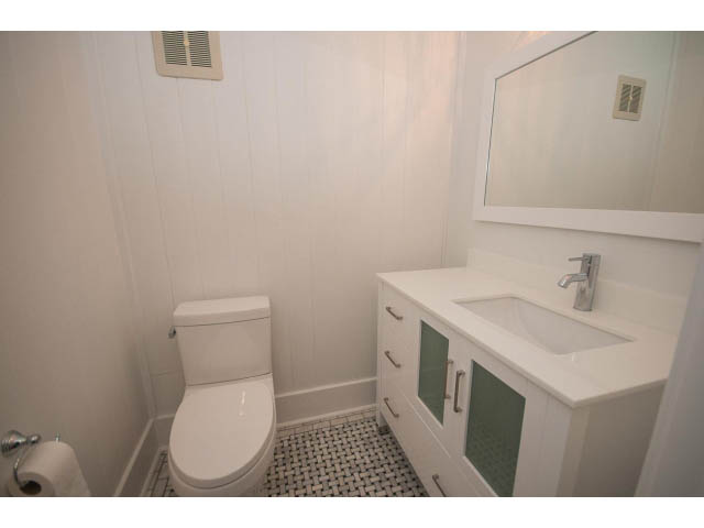 Bright bathroom with white cabinetry and a mosaic tile floor. - 516 E 10th Ave, Vancouver East Side