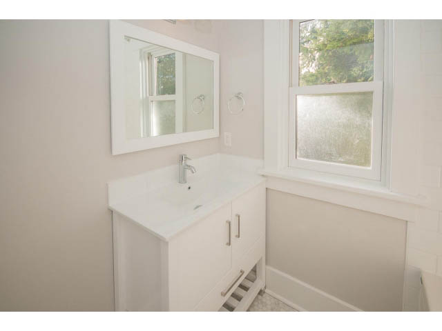 Bright bathroom with white vanity and frosted window. - 516 E 10th Ave, Vancouver East Side