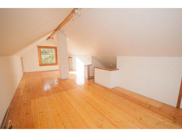 Bright attic room with hardwood floors and a small window. - 516 E 10th Ave, Vancouver East Side