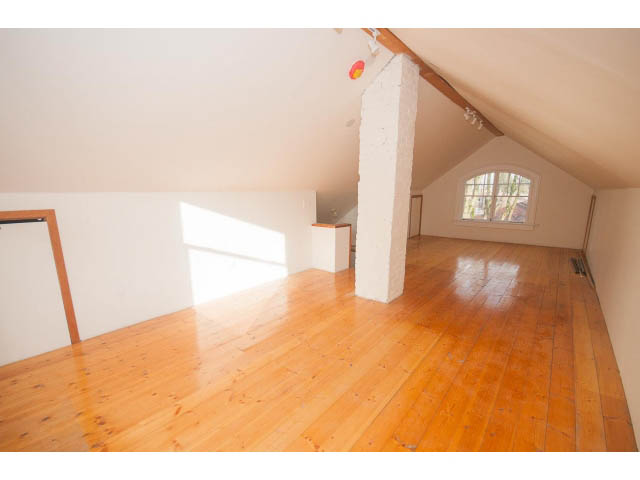 Bright attic space with wooden floors and exposed beams, natural light from window. - 516 E 10th Ave, Vancouver East Side