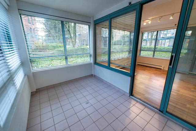 Furnished living room with hardwood floors and large windows, showcasing a city view. - 204 - 283 Davie Street, Vancouver Downtown