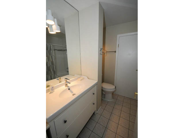 Bright bathroom with white vanity and tiled floor. - 1397 Tatlow Avenue, North Vancouver