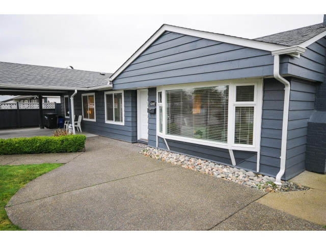 Furnished 3-bedroom + den house with modern siding, large windows, and a stone pathway. - 1397 Tatlow Avenue, North Vancouver