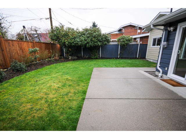 Spacious backyard with neatly trimmed grass and paved walkway leading to house. - 1397 Tatlow Avenue, North Vancouver