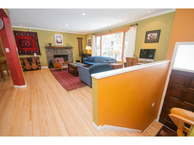 Furnished living room with hardwood floors, cozy seating, and a fireplace. - 2972 Wembley Dr, North Vancouver