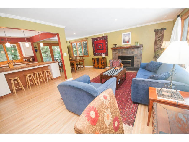 Spacious living room with hardwood floors, cozy seating, and a fireplace. - 2972 Wembley Dr, North Vancouver
