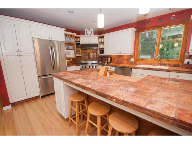 Bright kitchen with granite countertops, hardwood floors, and a city view. - 2972 Wembley Dr, North Vancouver