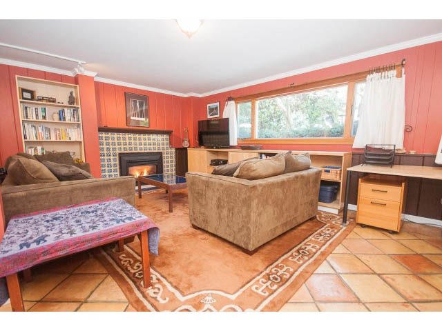 Bright living room with tiled floors, wooden furniture, and a large window. - 2972 Wembley Dr, North Vancouver