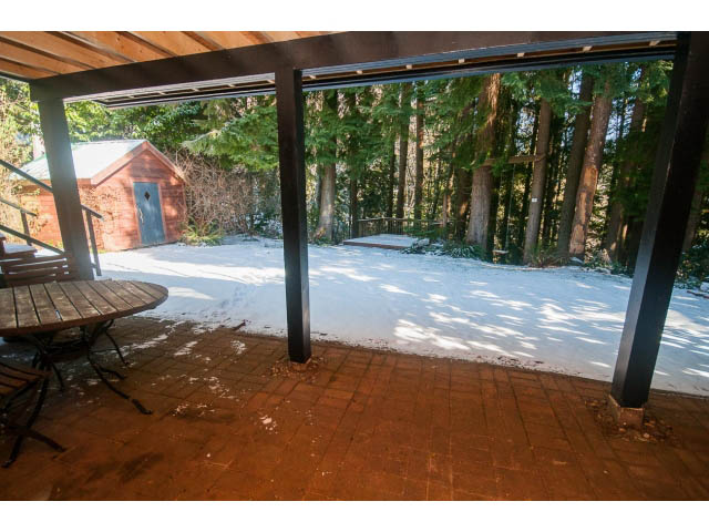 Patio with snow, wooden furniture, forest view. - 2972 Wembley Dr, North Vancouver