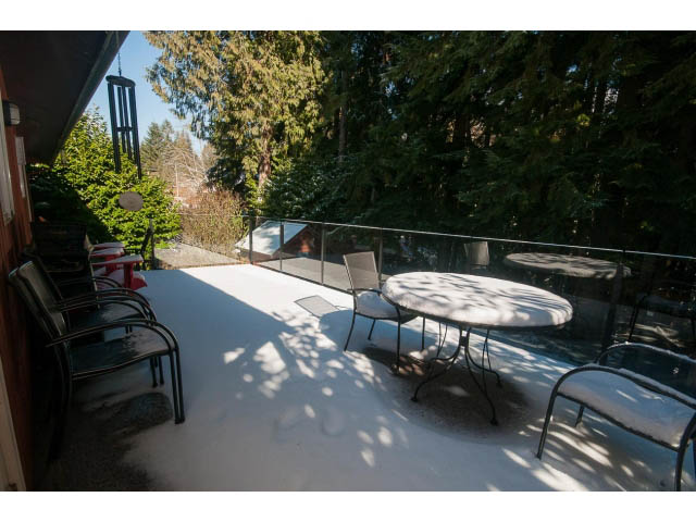 Furnished patio with snow-covered furniture and forest view. - 2972 Wembley Dr, North Vancouver