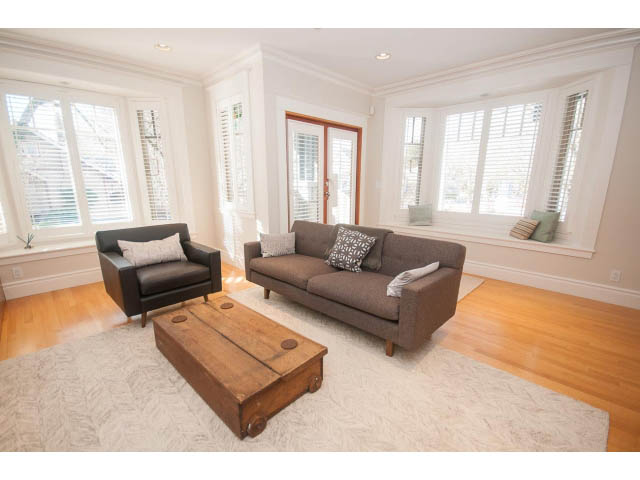 Spacious living room with hardwood floors, large windows, and a cozy sofa setup. - 398 W 13th Ave, Vancouver West Side