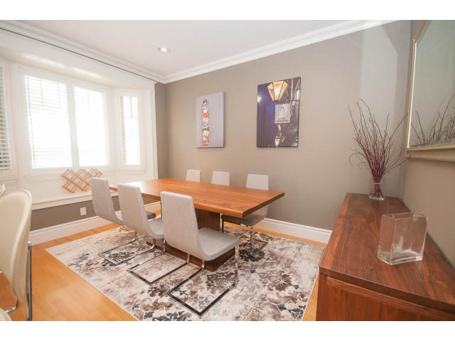 Furnished dining area with wooden table, modern chairs, and artwork on the wall. - 398 W 13th Ave, Vancouver West Side