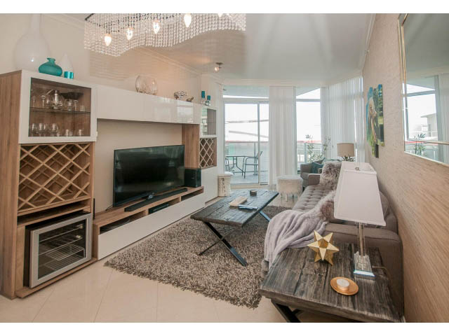 Spacious living room with modern decor, large windows, and a cozy corner. - 1008-199 Victory Ship Way, North Vancouver