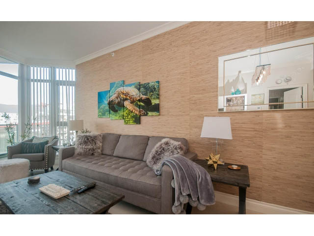 Furnished living room with a large turtle painting, modern decor, and a cozy ambiance. - 1008-199 Victory Ship Way, North Vancouver