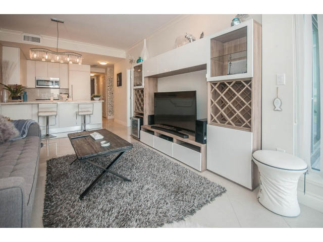 Furnished living room with hardwood floors, modern decor, and a cozy ambiance. - 1008-199 Victory Ship Way, North Vancouver
