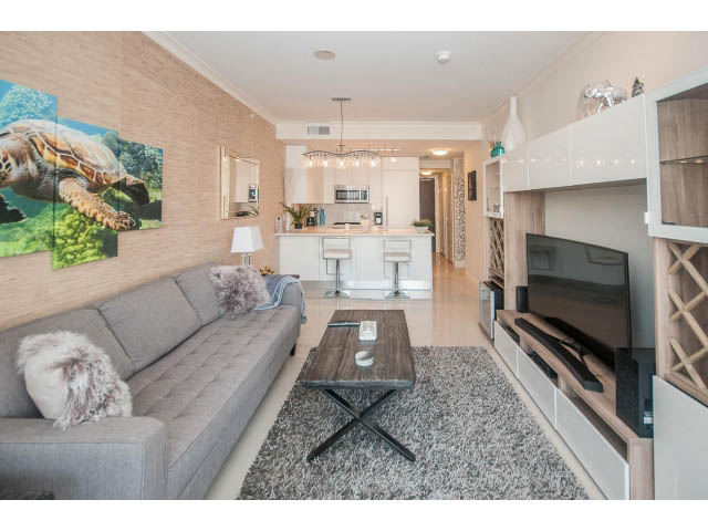 Furnished living room with a turtle painting, modern coffee table, and city view. - 1008-199 Victory Ship Way, North Vancouver