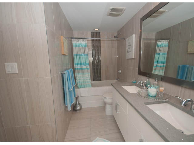 Furnished bathroom with light wood cabinets, modern sink, and glass shower door. - 1008-199 Victory Ship Way, North Vancouver
