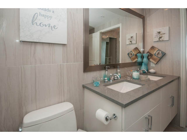 Furnished bathroom with light wood walls, modern sink, and decorative vases. - 1008-199 Victory Ship Way, North Vancouver