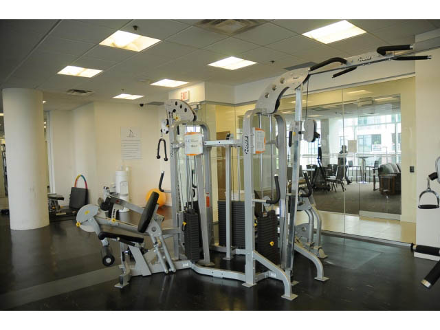 Bright gym with cardio equipment and mirrors, spacious and well-lit. - 1008-199 Victory Ship Way, North Vancouver