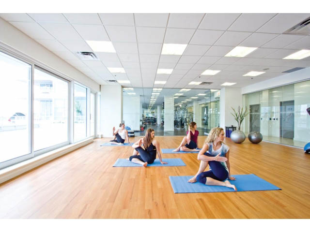 Spacious yoga studio with hardwood floors, large windows, and mirrored walls. - 1008-199 Victory Ship Way, North Vancouver