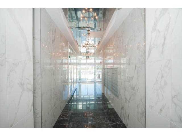 Spacious living room with marble walls and black marble flooring. - 1008-199 Victory Ship Way, North Vancouver