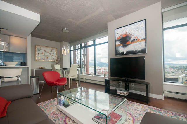Bright living room with modern decor, city view, and glass coffee table. - 3806 - 128 Cordova St W, Vancouver Downtown