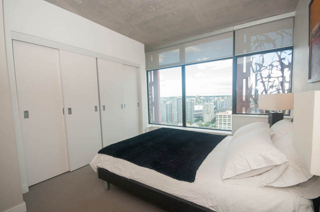 Spacious bedroom with sliding closet doors and a stunning city view. - 3806 - 128 Cordova St W, Vancouver Downtown