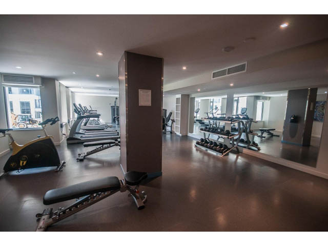 Spacious, well-lit gym with cardio equipment and mirrors. - 1108 - 1661 Quebec St, Vancouver West Side
