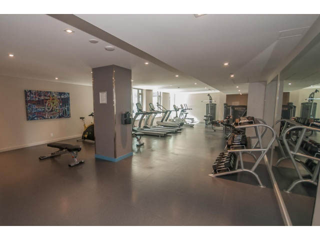 Spacious gym with treadmills, weight machines, and mirrors. - 1108 - 1661 Quebec St, Vancouver West Side