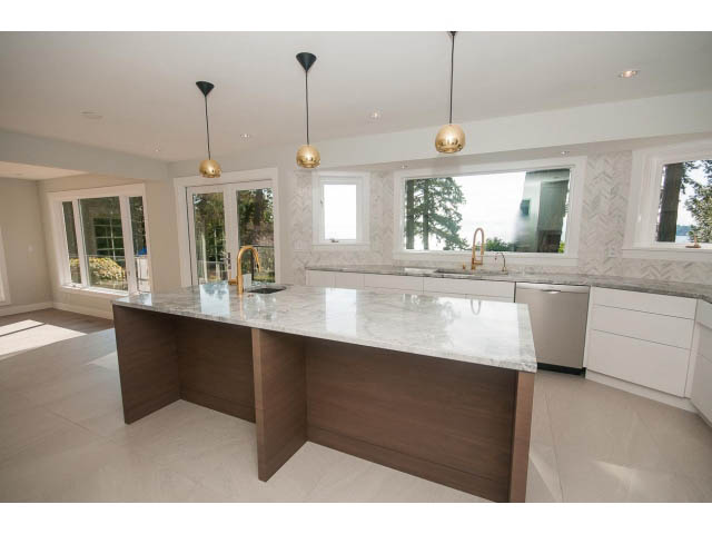 Bright kitchen with marble countertops, hardwood island, and city view. - 6018 Gleneagles Place, West Vancouver