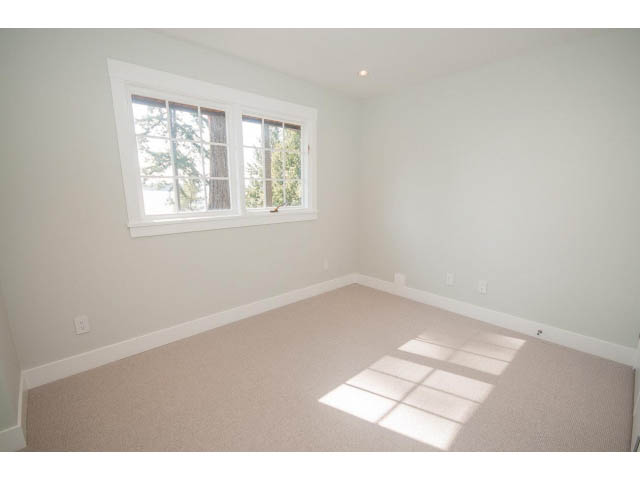 Bright bedroom with carpeted floor and large window, letting in natural light. - 6018 Gleneagles Place, West Vancouver
