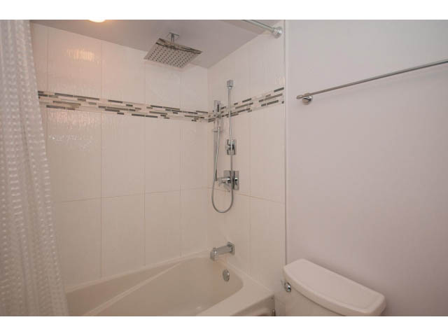 Furnished bathroom with bathtub and shower, white tiles, modern fixtures. - 202 - 1277 Nelson St, Vancouver Downtown