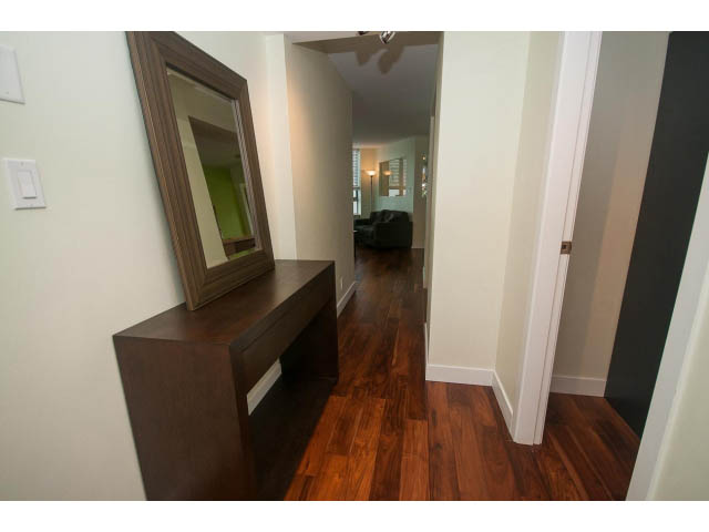 Bright hallway with hardwood floors and a dark wooden console table. - 202 - 1277 Nelson St, Vancouver Downtown