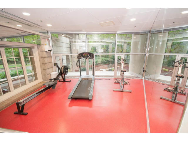 Bright gym with red flooring, large windows, and exercise equipment. - 202 - 1277 Nelson St, Vancouver Downtown