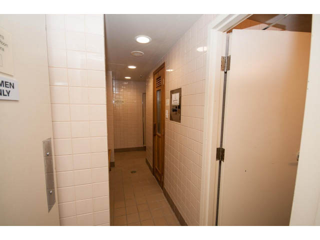 Men's bathroom with tiled walls and a sign indicating gender. - 202 - 1277 Nelson St, Vancouver Downtown