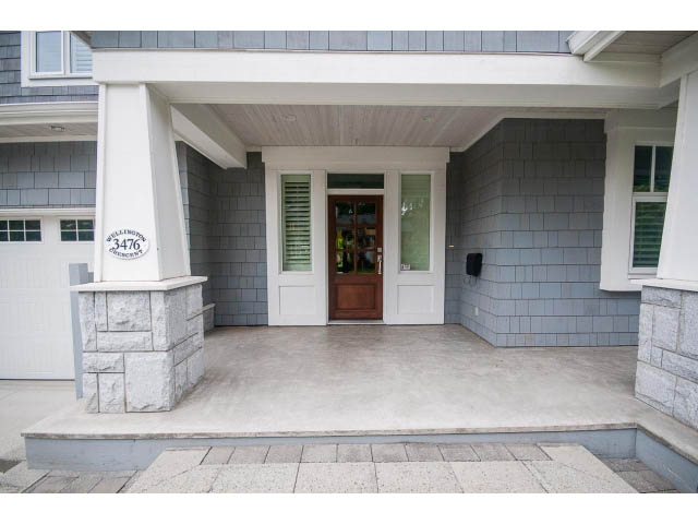 Bright front porch with stone steps and wooden door, showcasing a modern design. - 3476 Wellington Crescent, North Vancouver